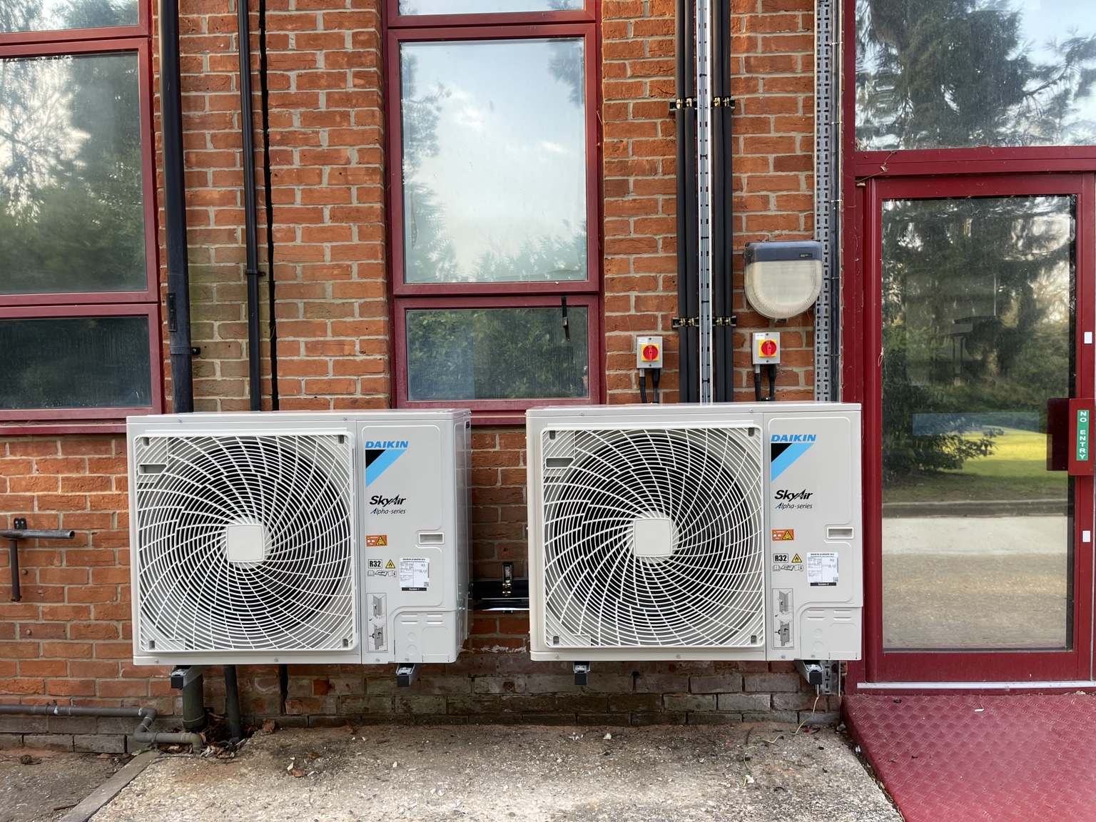 Two Daikin SkyAir outdoor units installed on a brick commercial building