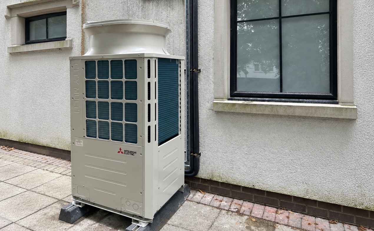 Side-angle view of a Mitsubishi Electric City Multi outdoor unit and externally routed refrigeration services at a UK college