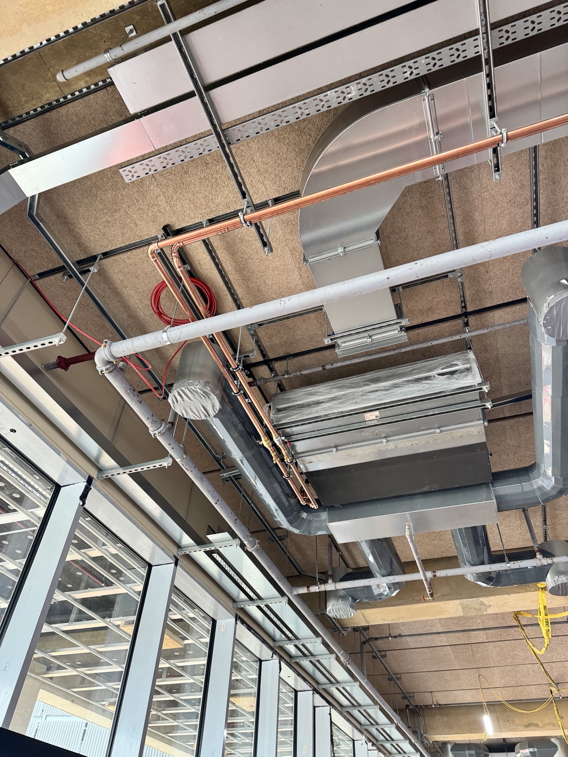Hybrid VRF indoor equipment and copper pipework installed above the future ceiling