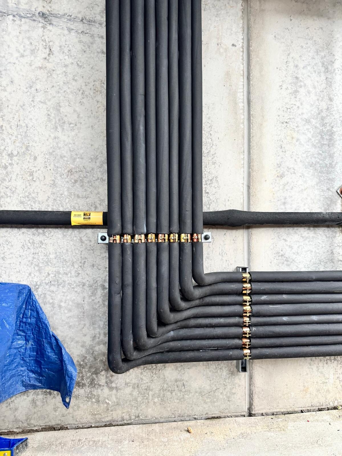 Neatly supported insulated refrigeration pipework with uniform bends